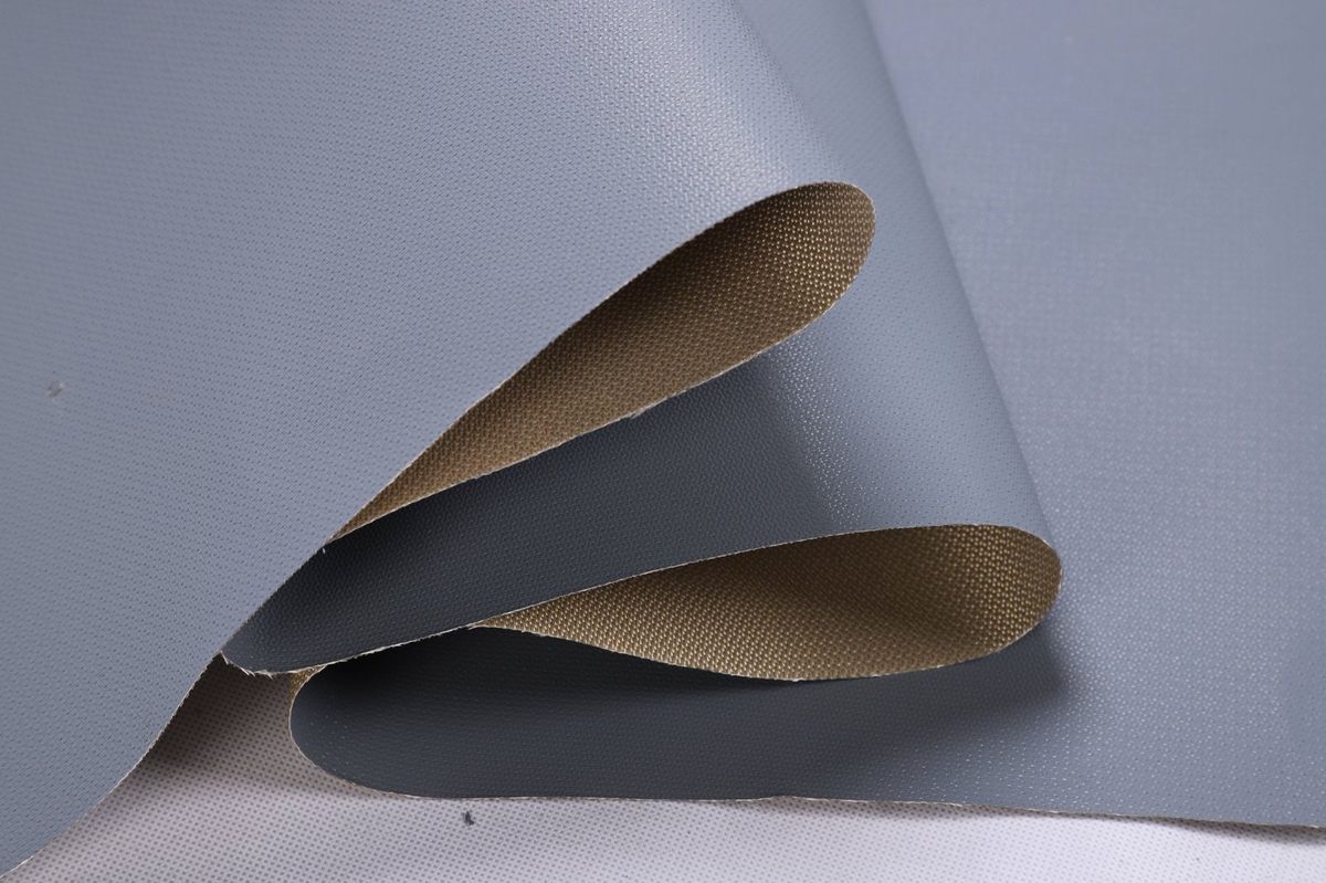 灰色 PTFE 涂层玻纤布折起,可见光滑灰色涂层面和本色玻纤背面